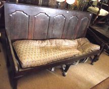 A large 18th/19th Century Oak Settle, with four panelled back, raised on short front cabriole