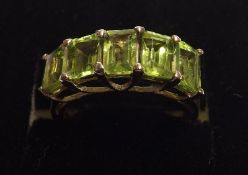 A White Metal Ring featuring five Emerald Cut Peridots, pavé set, stamped “.925”