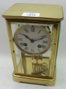 An early 20th Century French Lacquered Brass Four Glass Mantel Clock, the plinth-shaped case with