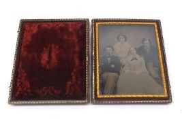 A large Ambrotype Family Group, depicting two young men and two young women, in a red plush-lined