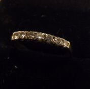 An unmarked yellow metal Half Hoop Ring, set with seven small Brilliant Cut Diamonds