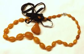 A good size yellow/orange Baltic Amber Necklace of oval form bead; plus a Natural Amber Pendant of
