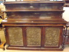 A Victorian Rosewood Chiffonier, the back with two narrow shelves, the body with three doors inset
