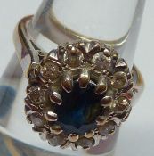 A hallmarked 18ct Gold centre oval Blue Sapphire and ten small Brilliant Cut Diamond Surround