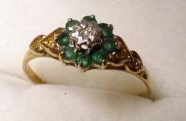 A hallmarked 9ct Gold centre small Diamond and small Emerald Surround Cluster Ring with carved