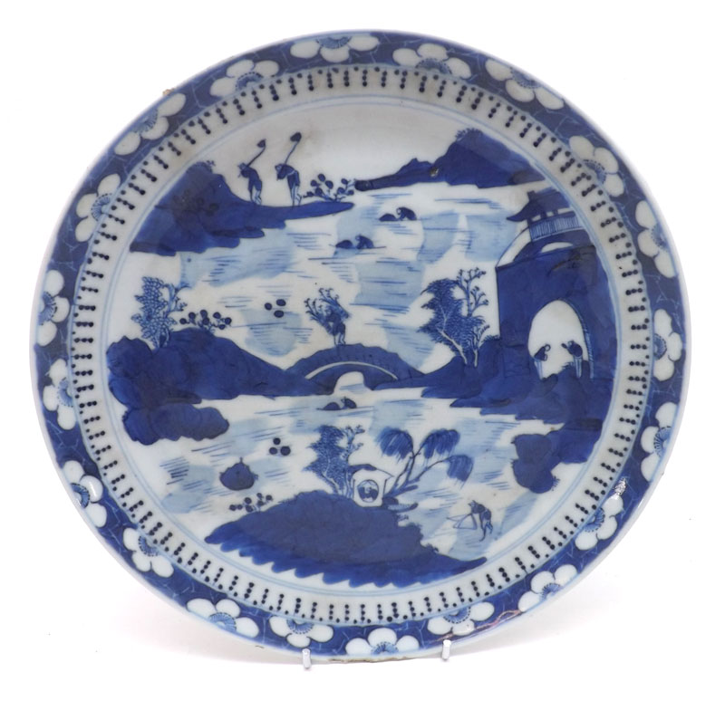 A Chinese Circular Plate, painted in underglaze blue with a central Chinese river scene with