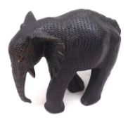 An Ebonised Mahogany Model of an elephant carved with textured skin, lacks tusks, 10” long