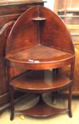 An early 19th Century Mahogany Bow Front Three Tier Corner Wash Stand on swept front feet, 26” wide