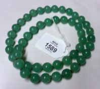 A Jade Bead Necklace, 60mmm long, approximately 12mm diameter beads