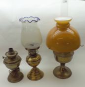 A Mixed Lot: two early 20th Century Oil Lamps with coloured glass shades and brass bodies,