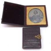 A small Ambrotype Study of a seated young woman, in embossed leatherette case with brass clasp, 2” x