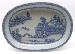 A Nankin Oval Dish, the centre painted in underglaze blue with a Chinese river scene, within a