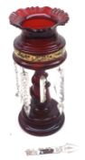 A Victorian Ruby Glass Lustre Vase with frilled rim, tapering stem with serpent detail, raised on