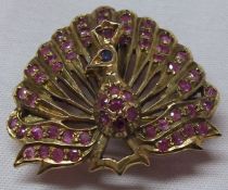 A (probably) Indian unmarked yellow metal peacock design Brooch/Pendant, set with red and blue