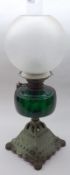 A late 19th Century Oil Lamp, frosted glass shade, clear glass chimney, green glass font, on a