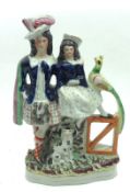 A 19th Century Staffordshire Figure Group of Scots couple, with attendance peacock and dog,