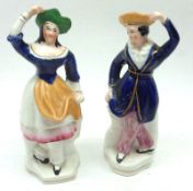 A pair of 19th Century Staffordshire Figures, modelled as a dancing couple, decorated in colours,