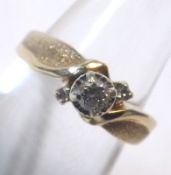 A yellow metal Ring marked 10K set with central Diamond and two small stones surrounding