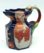 A 19th Century Octagonal Jug, with serpent-shaped handle, decorated in blues and oranges, the base