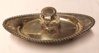 An Edward VII oval Inkstand with gadrooned edge, fitted with clear cut glass ink bottle (lid