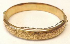 A 9ct Gold hallmarked Bracelet of plain oval form, the outer body chased with scrolling foliage,