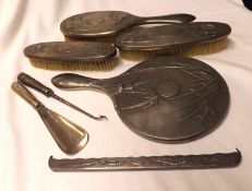 An Oriental Silver Plated Dressing Table Set, comprising Hand Mirror, three Brushes, Shoe Horn and