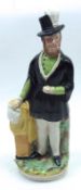 A 19th Century Staffordshire Figure of a suited gentleman on plinth base, decorated throughout in