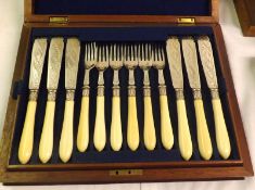 A cased set of twelve Silver Plated Fish Knives and matching Forks, decorated with a chased design