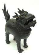 An Oriental Bronze Censor modelled as a temple dog, its head providing the hinged cover, 7” high