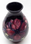 A modern Moorcroft Baluster Vase, decorated in an anemone pattern on a blue background, base with