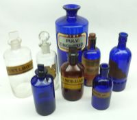 A group of eight Blue, Amber and Clear Vintage Chemists Bottles, the largest 9” high