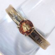 A 9ct Gold hallmarked Ring set with an Orange Sapphire and two small Diamonds