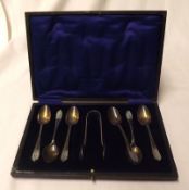A cased set of six Teaspoons with foliate decorated finials, Sheffield 1926; together with