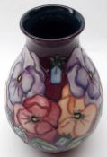 A Moorcroft Wide-Necked Baluster Vase, decorated in pansy pattern on a dark purple background,