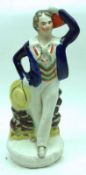 A 19th Century Staffordshire Figure of a gent seated on a tree stump, decorated in colours (probably