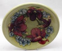 A Moorcroft Shallow Bowl, decorated with an orchid pattern on a yellow background, 8 ½” wide, base