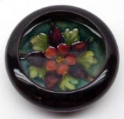 A small Moorcroft Shallow Bowl. Columbine pattern, with floral decorated centre on a turquoise