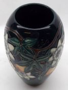 A modern Moorcroft Wide-Necked Vase, decorated with a passion flower design on a green/blue