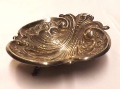 A Continental White Metal Shell-formed Butter Dish, raised on three swept feet, bears marks K Inc