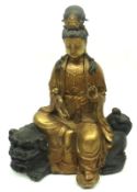 A 20th Century gilded Bronze Model of a seated Deity, seated on Bronze patinated Kaolin clutching