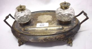 An oval Silver Plated Inkstand with two clear glass ink bottles, raised on a four-footed base, 10”
