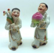 Two 20th Century Chinese Figures, one modelled as a boy wearing a gilt-trimmed robe and clutching