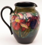 A large Moorcroft Wide-Necked Jug, decorated with an Orchid pattern on a blue/turquoise