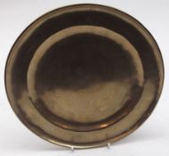 An Eastern Brass or Bronze Circular Plate, incised floral and mythological decoration, 8 ½” diameter