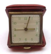 A Vintage Swiza Travelling Alarm Clock, square face with pale green Arabic numerals and outside