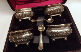 A Cased Set of Four Late Victorian Salts, boat-shaped, half-fluted decoration and each standing on