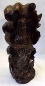 A 20th Century Hardwood Carved Figure of Guanyin standing before a Tobacco Leaf, 16” high