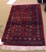 A 20th Century Pakistan Shiraz Carpet, decorated with elephant foot designs on a red field, 1.8m x.