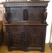 A heavily carved Oak Court Cupboard constructed from period timbers, the base with two doors and two