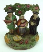 A Staffordshire Tithe Group Figure comprising: A Couple with a Baby and Dog and a Praying Priest,